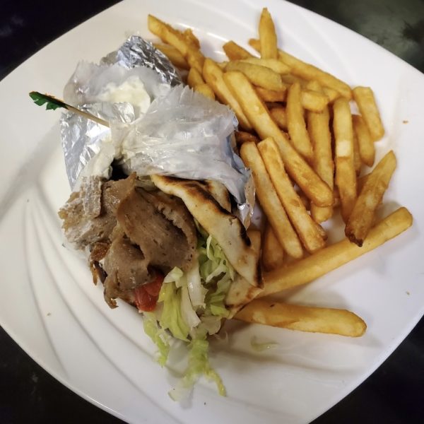gyro made of grilled lamb strips on pita with lettuce, tomato, onion, and tzatziki sauce, served with french fries