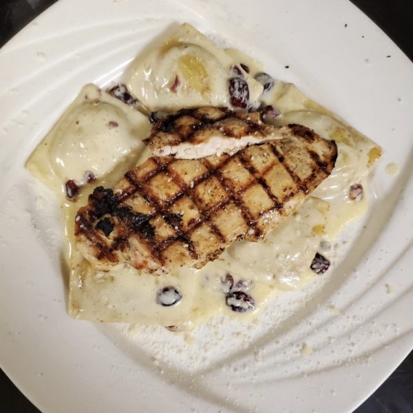pumpkin ravioli in a cranberry cream sauce, topped with chicken breast