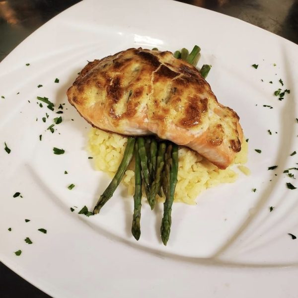 crab stuffed salmon baked with imperial sauce, served over rice and asparagus