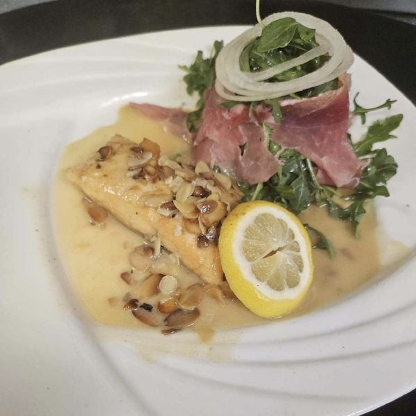 salmon in a lemon white wine butter sauce with almonds served with an arugula and prosciutto salad with balsamic dressing
