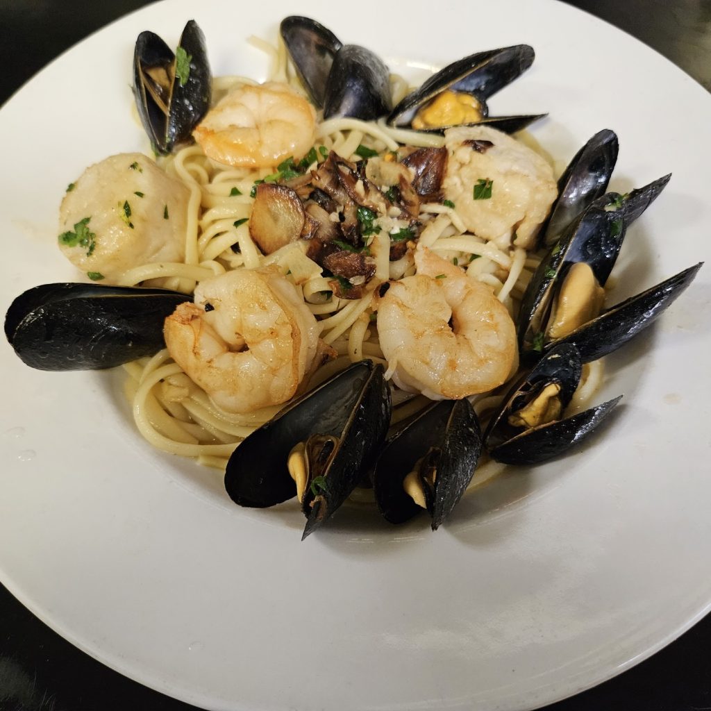sautéed scallops, shrimp, and jumbo mussels with garlic white wine sauce over linguine